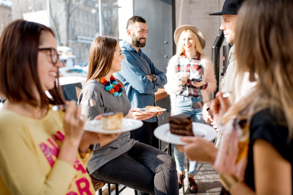 A group of co-workers enjoying food and drinks together at a lively event.